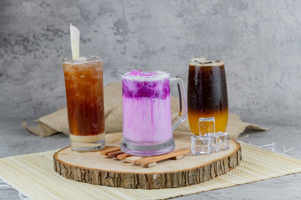 Three refreshing iced drinks on a wooden tray, perfect for a summer day.